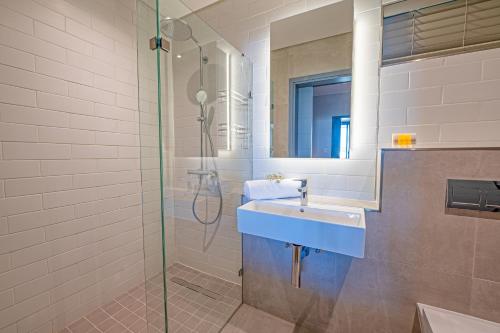 a bathroom with a sink and a shower at Luxury Beachfront Studio in Blouberg in Bloubergstrand