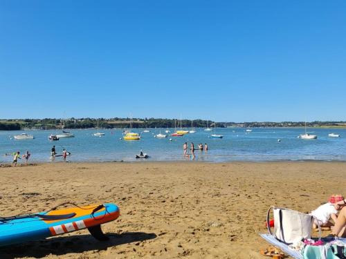 une plage avec un groupe de personnes dans l'eau dans l'établissement Maison Amarée, à Pleudihen-sur-Rance