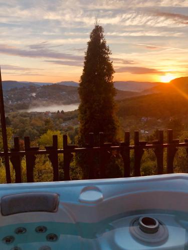 a bath tub with a view of the sunset at Felhőfészek vendégház in Verőce