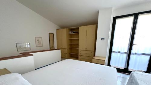 a bedroom with a white bed and a large window at M328 - Marcelli, bilocale con vista mare in Marcelli