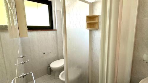 a bathroom with a toilet and a shower with a window at M328 - Marcelli, bilocale con vista mare in Marcelli