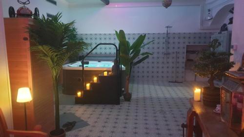a bathroom with a tub with candles and plants at Les 2 Drôles d'Oiseaux in Luc-sur-Orbieu