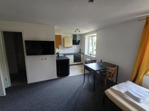 AdelsriedにあるLivBiz Apartments - Adelsriedのテーブルとキッチンのあるリビングルーム