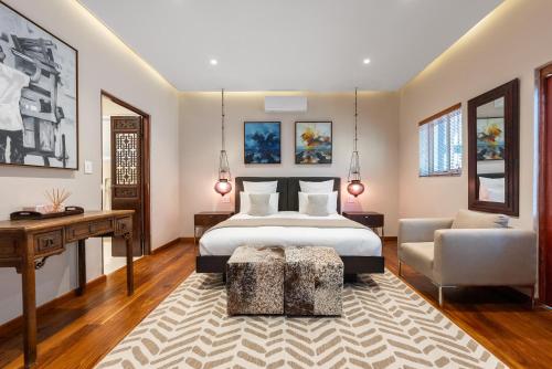 a bedroom with a bed and a desk and a chair at The Cape Bali Luxury Villa with Ocean Views in Camps Bay in Cape Town