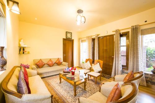 a living room with a couch and a table at Alaya Stays 2 BHK with Garden & Balcony - Villa Harmony in Bhowāli