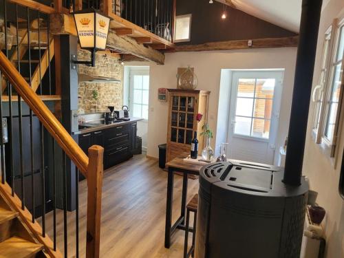 - une cuisine avec un escalier et une cuisinière dans une chambre dans l'établissement La petite maison du chineur, à Vincelles