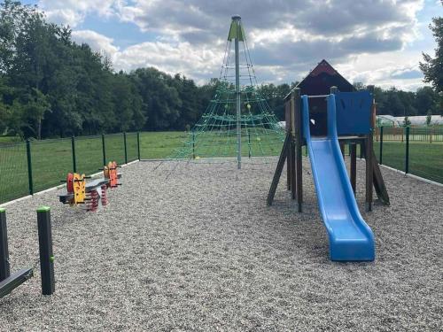 une aire de jeux avec un toboggan bleu dans un parc dans l'établissement La petite maison du chineur, à Vincelles