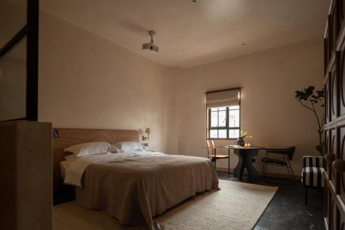 a bedroom with a bed and a table and a window at 归相Golden Age酒店 in Chengdu