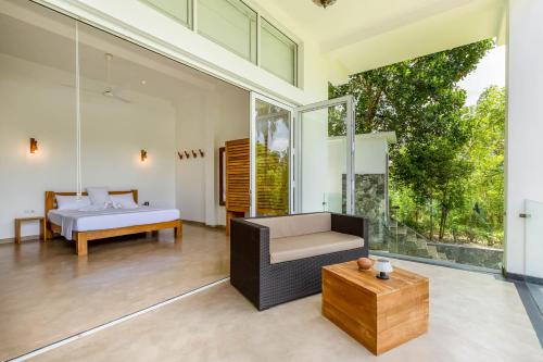 a living room with a bed and a couch at Samalanka Boutique Hotel in Habaraduwa