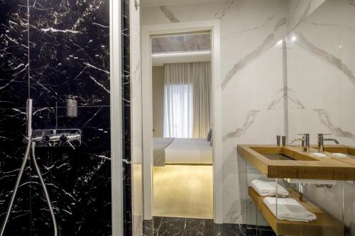 a bathroom with a shower and a sink and a bed at Hotel Regno in Rome