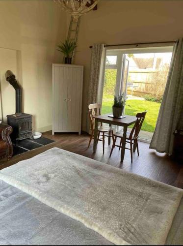 a living room with a table and a fireplace at Beautiful Cotswold Couples Retreat in Bourton on the Water