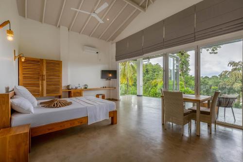 a bedroom with a bed and a table and chairs at Samalanka Boutique Hotel in Habaraduwa