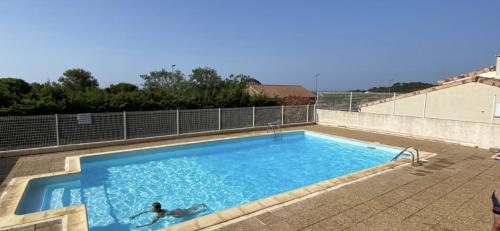 a person is swimming in a swimming pool at Résidence Cap de l esterel in Hyères