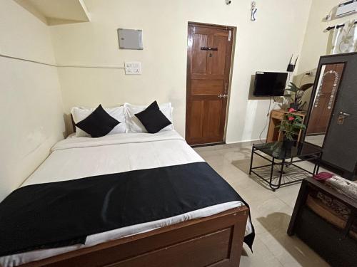a bedroom with a large bed and a television at Lourdina 3bhk Apartment in Candolim