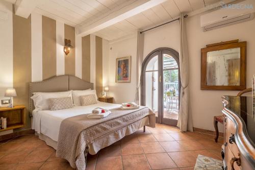 a bedroom with a bed and an open door at Restored Historic Mansion Paterno with Exclusive Pool, Wifi and AC for 20 people in Alghero