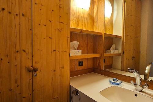 - une cuisine avec des murs en bois, un évier et un comptoir dans l'établissement Le Repère du Chat - Pied Des Pistes - Les Coches, à Les Coches