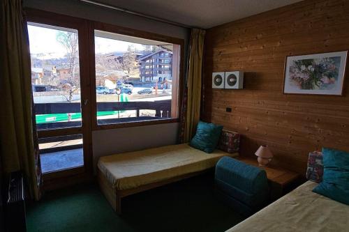 Cette petite chambre dispose d'une fenêtre avec un lit et une chaise. dans l'établissement Le Repère du Chat - Pied Des Pistes - Les Coches, à Les Coches