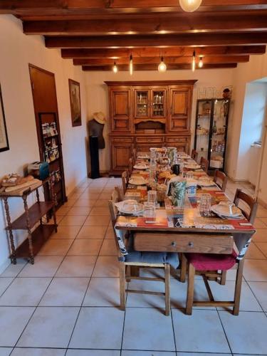 une grande salle à manger avec une grande table en bois dans l'établissement le gite du saladou- Cantal, à Mont-Chanson
