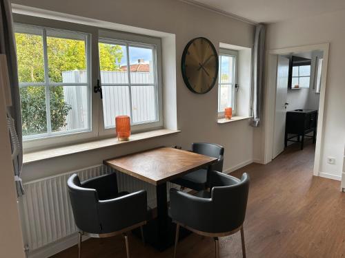 a dining room with a table and chairs and a clock at Living 77 in Fulda
