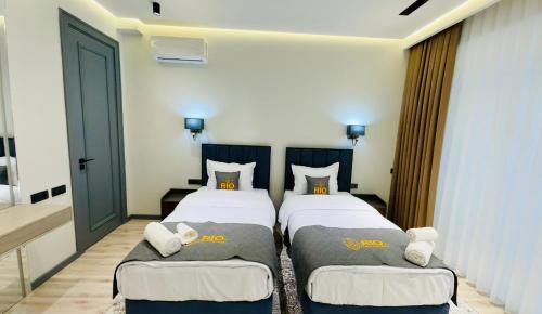 two twin beds in a room with a door at RIO Hotel in Samarkand
