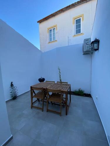 a patio with a wooden table and two benches at Casa da Cidade in Évora