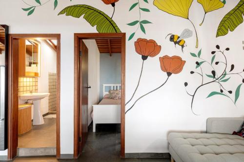 a living room with a wall mural of flowers and a bee at El Jardín de las Pléyades in Los Llanos de Aridane