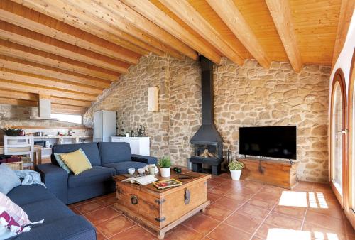 a living room with a blue couch and a stone wall at Vistas de ensueño y chimenea - Casa de las Letras in Lledó