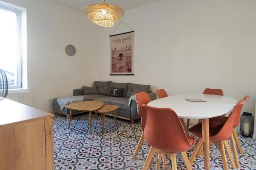 un salon avec un canapé, une table et des chaises dans l'établissement Maison sablaise rénovée avec goût, idéalement située, proche plage et commerces quartier Arago Les Sables - 6 personnes, à Les Sables-dʼOlonne