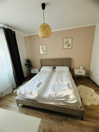 a large bed in a bedroom with a pendant light at A's apartment in Onești