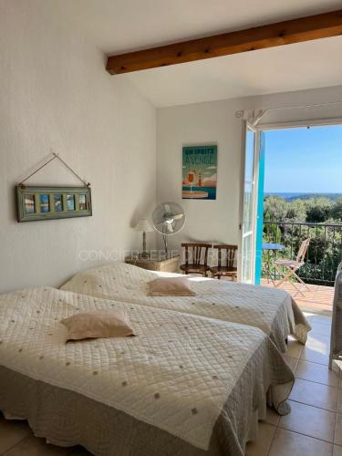 une chambre avec un grand lit et un balcon dans l'établissement Villa au calme avec piscine, à Roquebrune-sur Argens