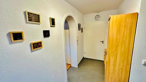 a hallway with pictures on the wall and a clock at Daheim am Wasserturm in Wörth am Rhein