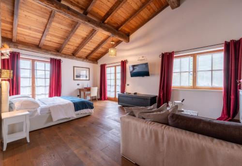 sypialnia z łóżkiem i kanapą w obiekcie Hotel Relais Vecchio Maso w Trydencie