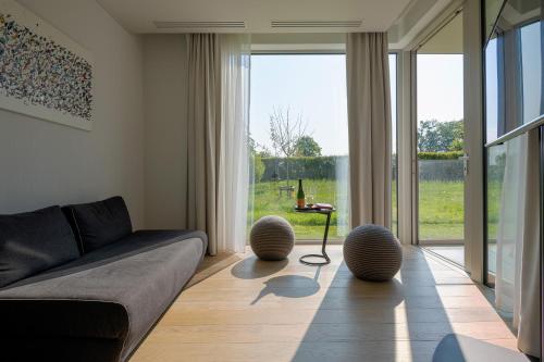 a living room with a couch and a large window at Martin's Rentmeesterij in Bilzen