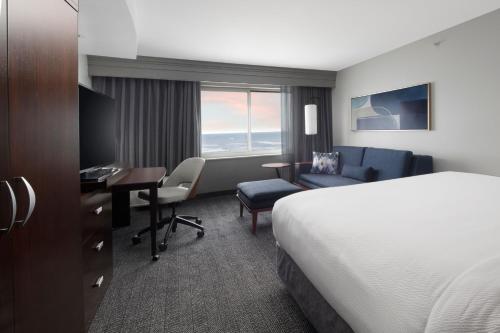a hotel room with a bed and a desk at Courtyard by Marriott Galveston Island in Galveston