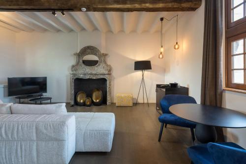 a living room with a couch and a fireplace at Martin's Rentmeesterij in Bilzen