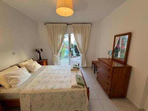 a bedroom with a bed and a dresser and a window at Beautiful 1-bd Ap near the beach historic places in Paphos