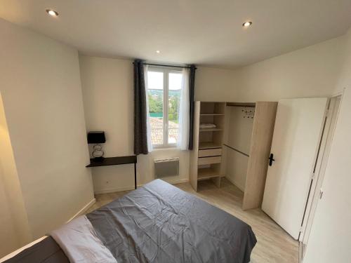 une petite chambre avec un lit et une fenêtre dans l'établissement 2 pièces au calme, à Cannes