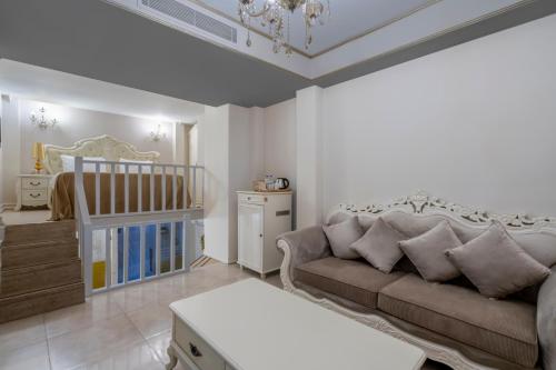 a living room with a couch and a baby crib at Elegance East Hotel in Antalya