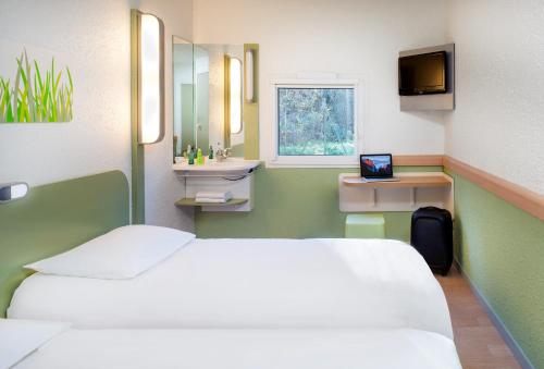 a hospital room with a bed and a mirror at Hotel Ibis Budget Vichy in Bellerive-sur-Allier