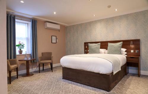 a bedroom with a large bed and a table and chairs at Kingston Theatre Hotel in Hull