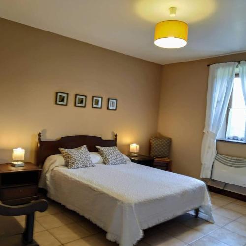 une chambre avec un lit et deux lampes et une fenêtre dans l'établissement Charming Courtyard cottage 25kms Puy du Fou, à Monsireigne