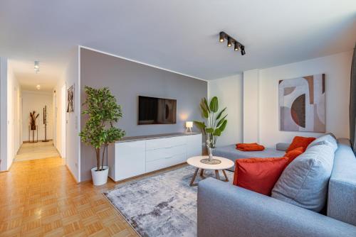 a living room with a blue couch and a tv at Stadtapartments Luna by Cosy Homes in Villach