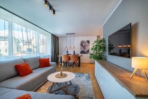 a living room with a couch and a table at Stadtapartments Luna by Cosy Homes in Villach