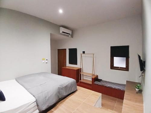 a bedroom with a bed and a dresser and a mirror at Urbanview House of IKIGAI in Madiun