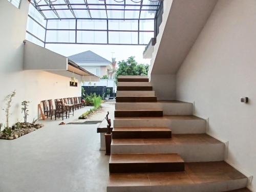 a staircase in a house with a glass ceiling at Urbanview House of IKIGAI in Madiun