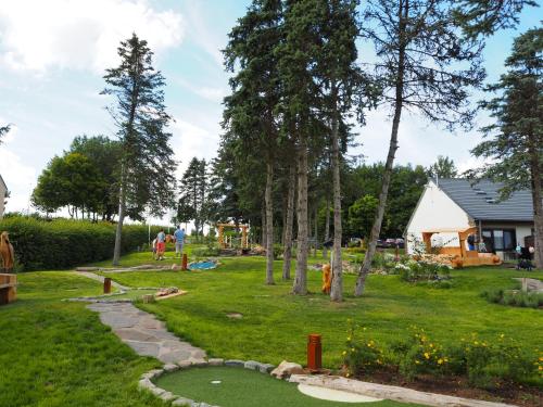 a yard with a playground and people playing golf at Holiday Park La Sapinière in Hosingen