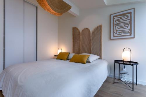 - une chambre avec un lit blanc et 2 oreillers jaunes dans l'établissement Full Loft, à Toulouse
