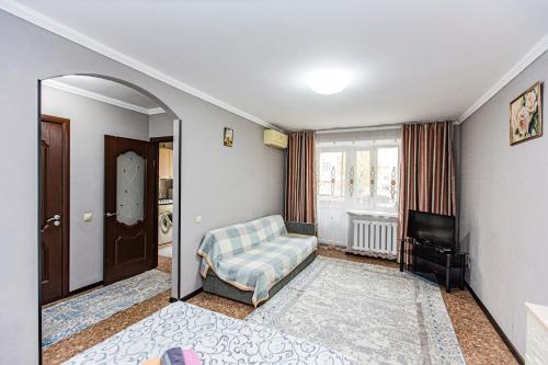 ein Wohnzimmer mit Sofa und Fernseher in der Unterkunft Комфортные апартаменты в центре города, Евро однушка #19 in Almaty