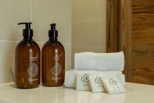 - deux bouteilles de savon et quelques serviettes sur un comptoir dans l'établissement Maison neuve- 5 minutes du lac, à Saint-Jorioz