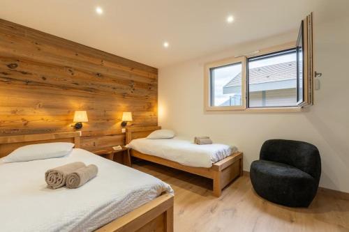 une chambre avec deux lits et une chaise et une fenêtre dans l'établissement Maison neuve- 5 minutes du lac, à Saint-Jorioz